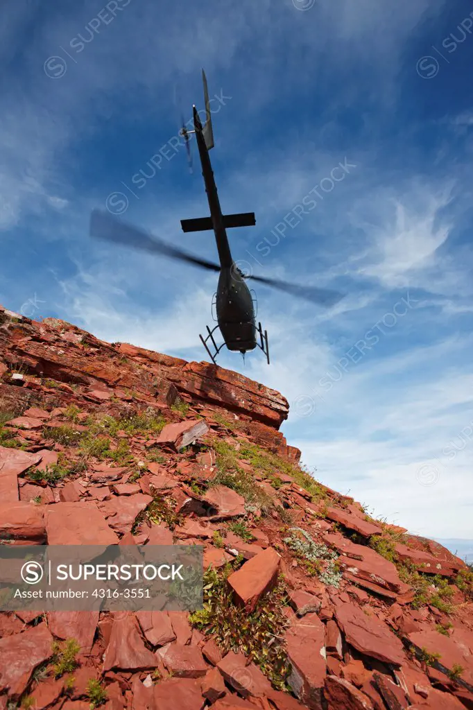 An OH-58 Kiowa, of the Colorado Army National Guard, lifts off from the edge of a cliff at 11,000 feet in Colorado's Rocky Mountains.