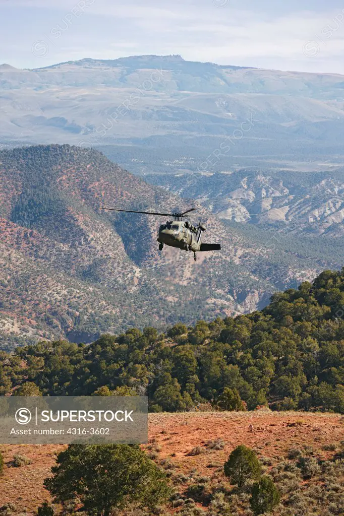 A Sikorsky UH-60 Blackhawk helicopter prepares to land at a high altitude landing zone in Colorado's Rocky Mountains.