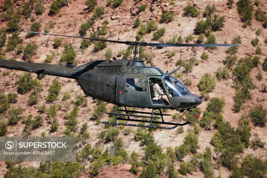 A Bell OH-58 Kiowa flies in the Rocky Mountains of Colorado.