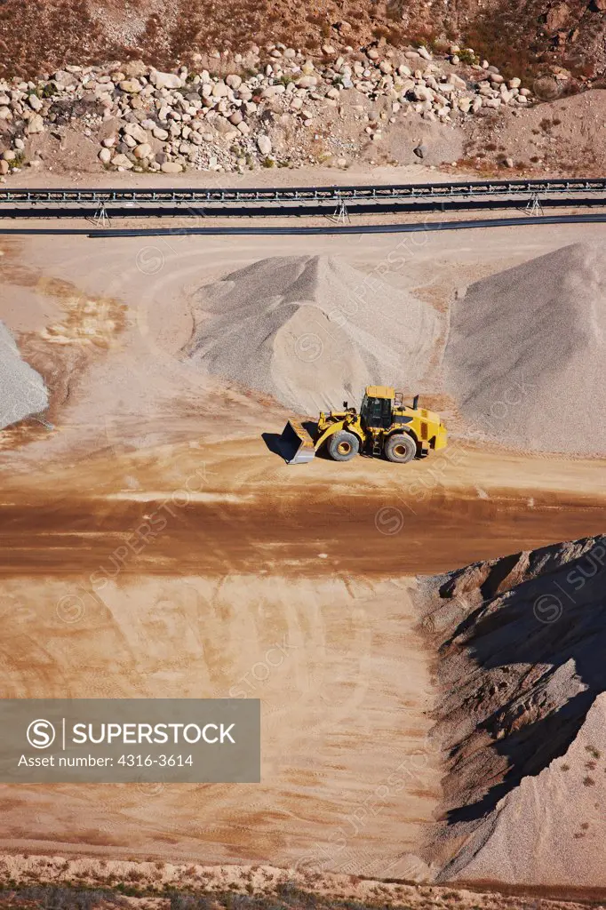 Aerial view of a front end loader in a gravel quarry.