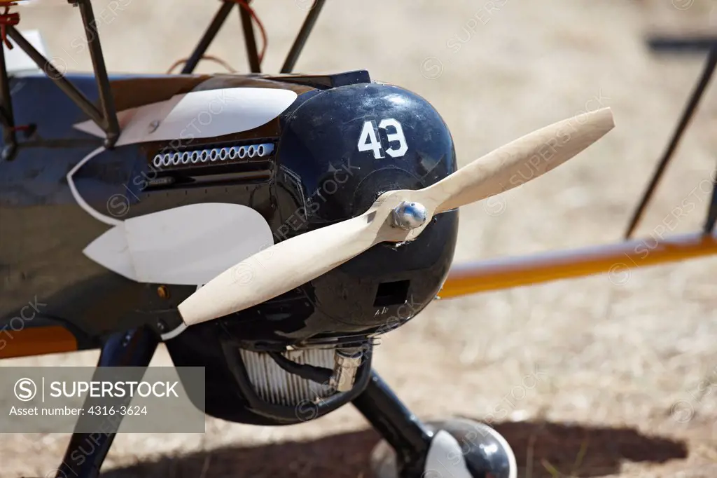 Detail of the nose of a radio controlled model airplane, showing engine cowling and propeller.