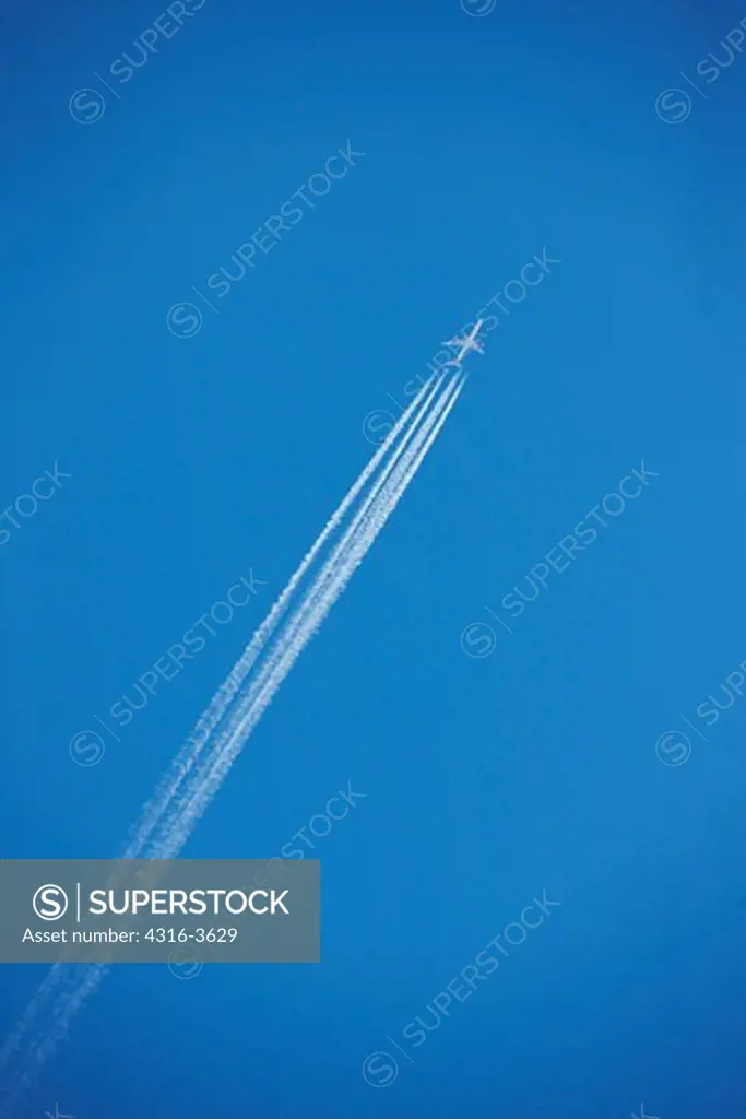 Airliner flying at a high altitude with condensation trails in its wake.