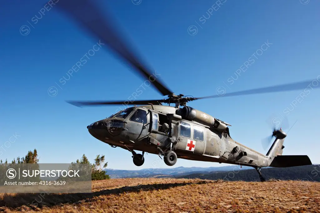A Sikorsky UH-60 Blackhawk helicopter, configured for medevac operations, lands at a landing zone at 10,000 feet above sea level, in Colorado's Rocky Mountains. This aircraft is a U.S. Army UH-60 Dustoff Air Ambulance Medevac Blackhawk.