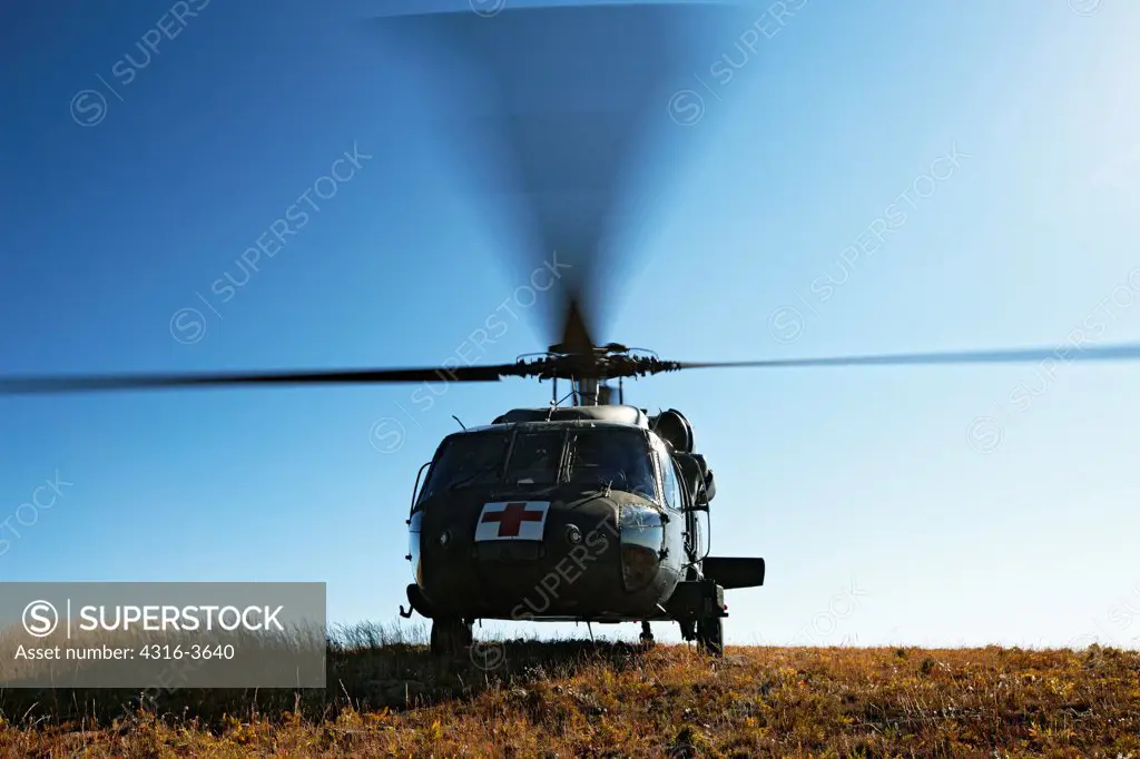 A Sikorsky UH-60 Blackhawk helicopter, configured for medevac operations, idles at a landing zone at 10,000 feet above sea level, in Colorado's Rocky Mountains. This aircraft is a U.S. Army UH-60 Dustoff Air Ambulance Medevac Blackhawk.