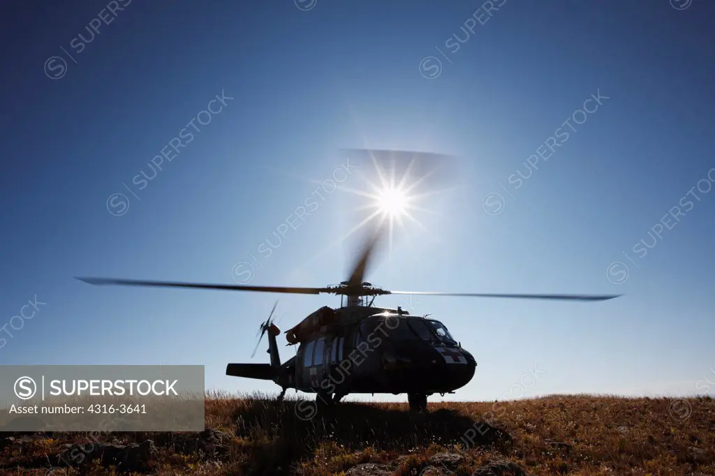 A Sikorsky UH-60 Blackhawk helicopter, configured for medevac operations, idles at a landing zone at 10,000 feet above sea level, in Colorado's Rocky Mountains. This aircraft is a U.S. Army UH-60 Dustoff Air Ambulance Medevac Blackhawk.