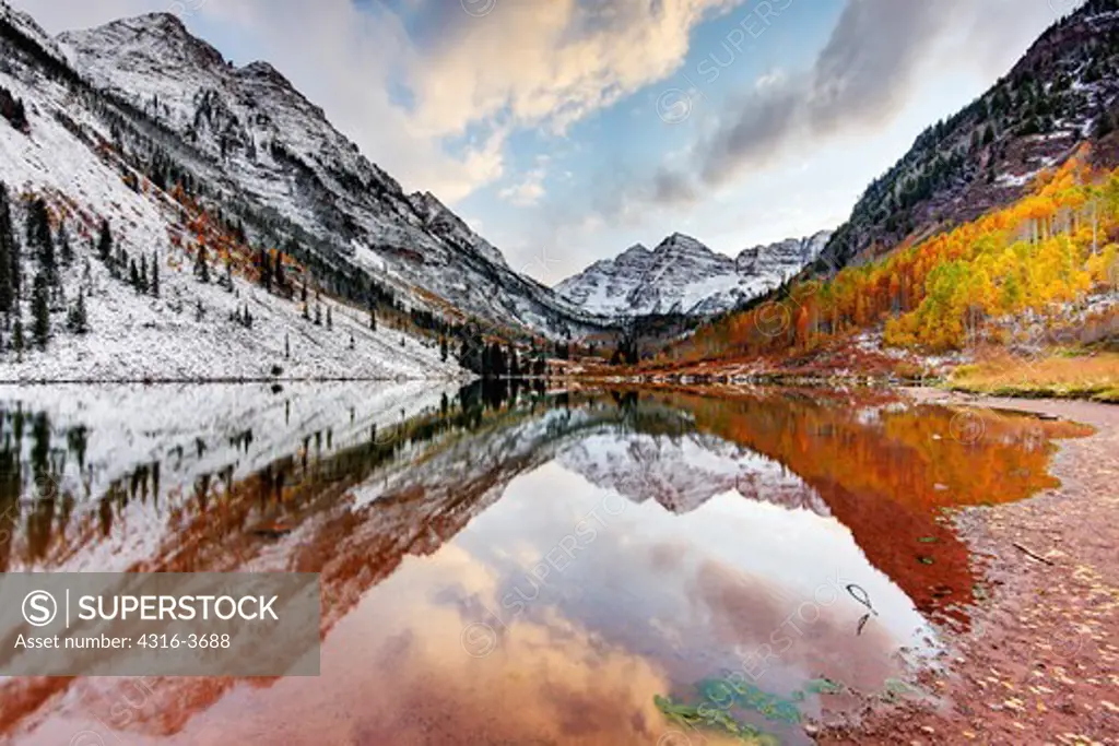 Maroon Peak, left, and North Maroon Peak, right, also known as The Maroon Bells, reflected in Maroon Lake. Maroon Peak is 14,163 feet, or 4,318 meters above sea level and North Maroon Peak is 14,014 feet, or 4,273 meters above sea level. They are in the Aspen, Colorado region. High Dynamic Range, or HDR image.