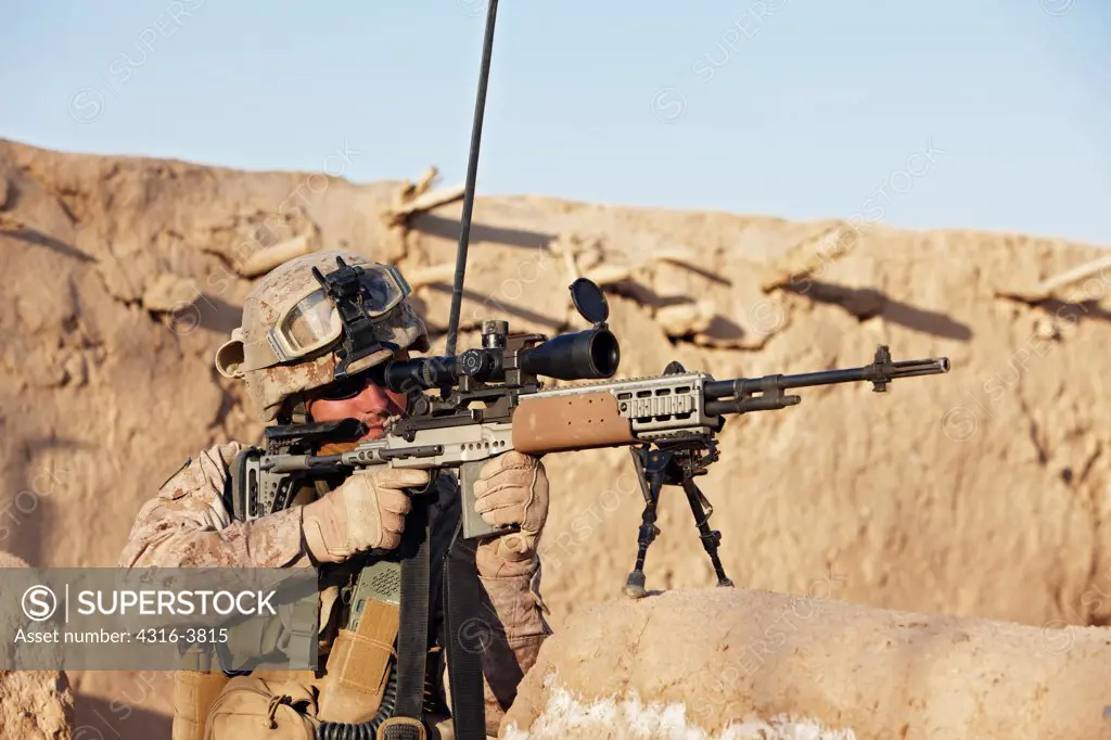 A U.S. Marine Aims a Rifle During a Combat Operation Outside the City of Marjah, Helmand Province of Afghanistan