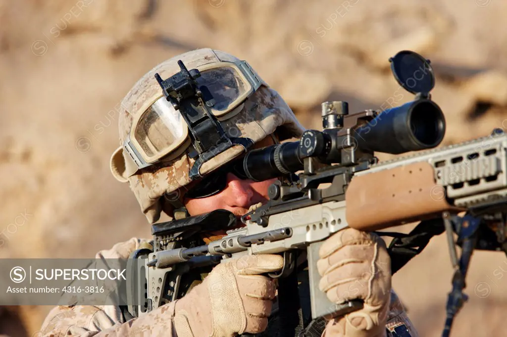 A U.S. Marine Aims a Rifle During a Combat Operation Outside the City of Marjah, Helmand Province of Afghanistan
