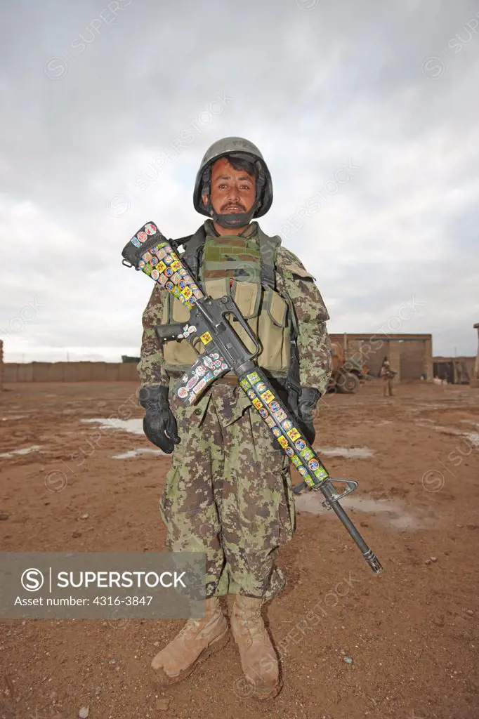 Afghan National Army Soldier With a U.S. Supplied M16 Rifle Adorned With Childish Colorful Stickers at a Remote, Austere Combat Outpost in Afghanistan's Helmand Province