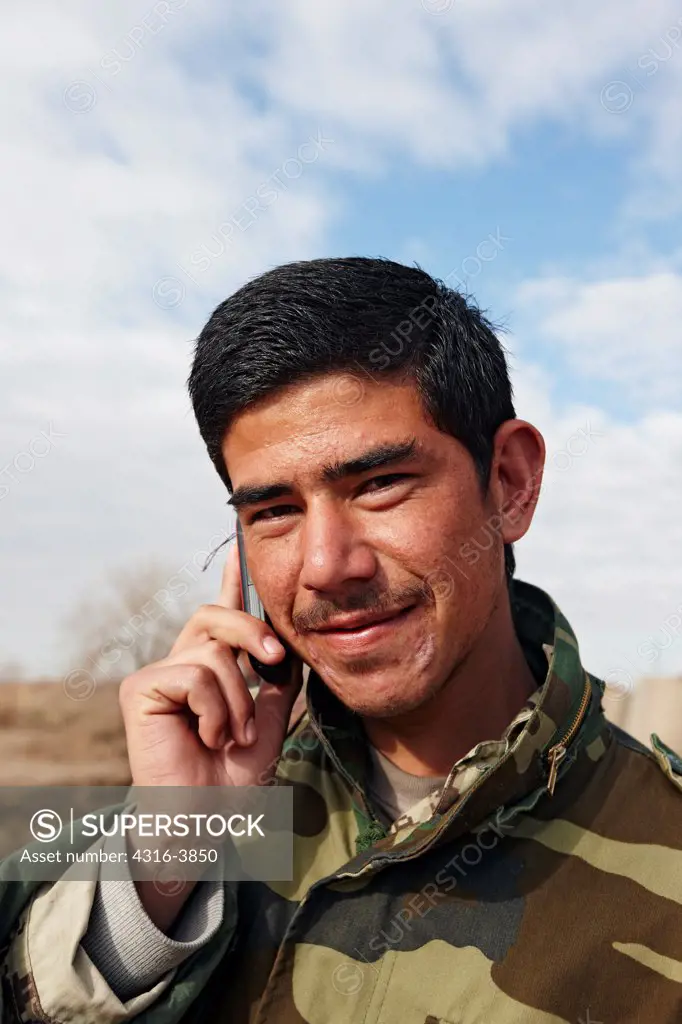 Afghan National Police Officer Talks on a Cell Phone