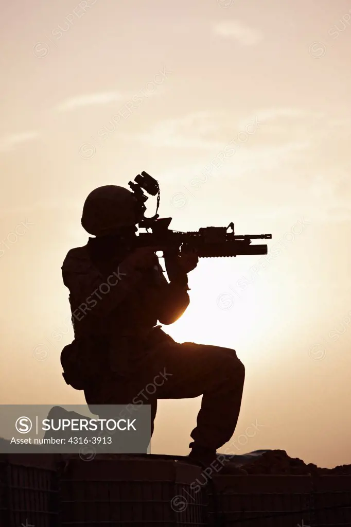 Silhouette of a U.S. Marine Aiming an M4 Carbine During a Combat Operation in Afghanistan's Helmand Province