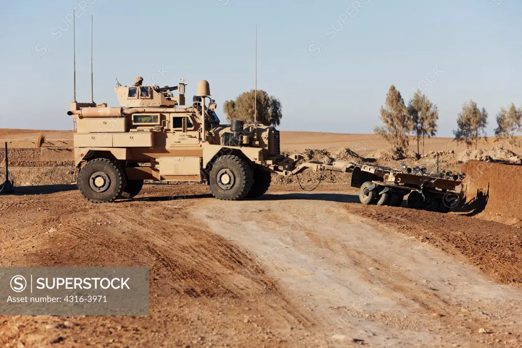 A U.S. Marine Corps MRAP, or Mine Resistant Ambush Protected Vehicle with a Mine Roller, on a Dirt Road in Afghanistan's Helmand Province