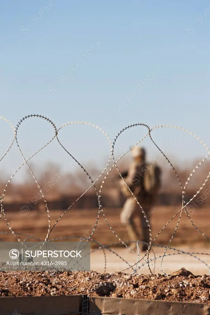 View Through Coil of Concertina Razor Wire of a U.S. Marine on Patrol Outside of a Combat Outpost in Afghanistan's Helmand Province