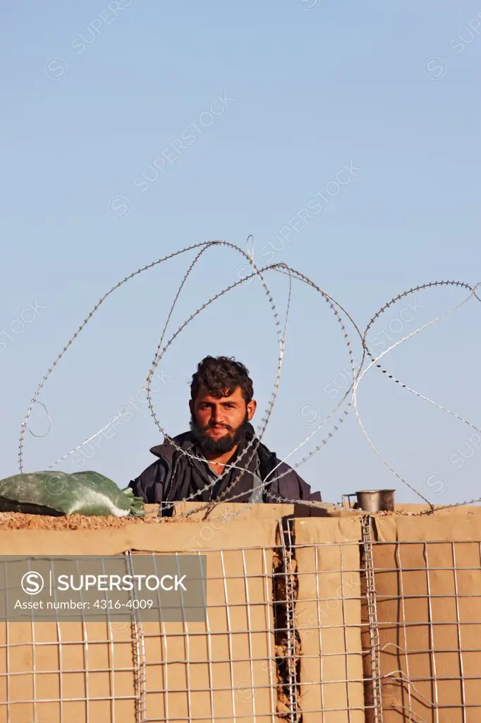 View of an Afghan National Army Soldier Through Concertina Razor Wire, Combat Outpost in Afghanistan's Helmand Province