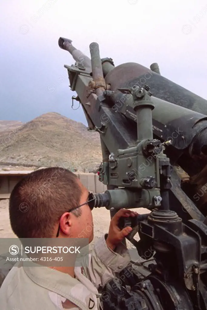 An Army Artilleryman Adjusts A 155mm Howitzer Heavy Artillery Piece