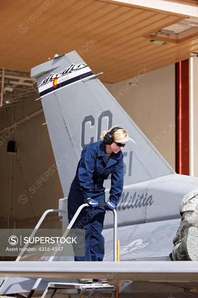 Tail of an F-16 and an Aircraft Maintainer