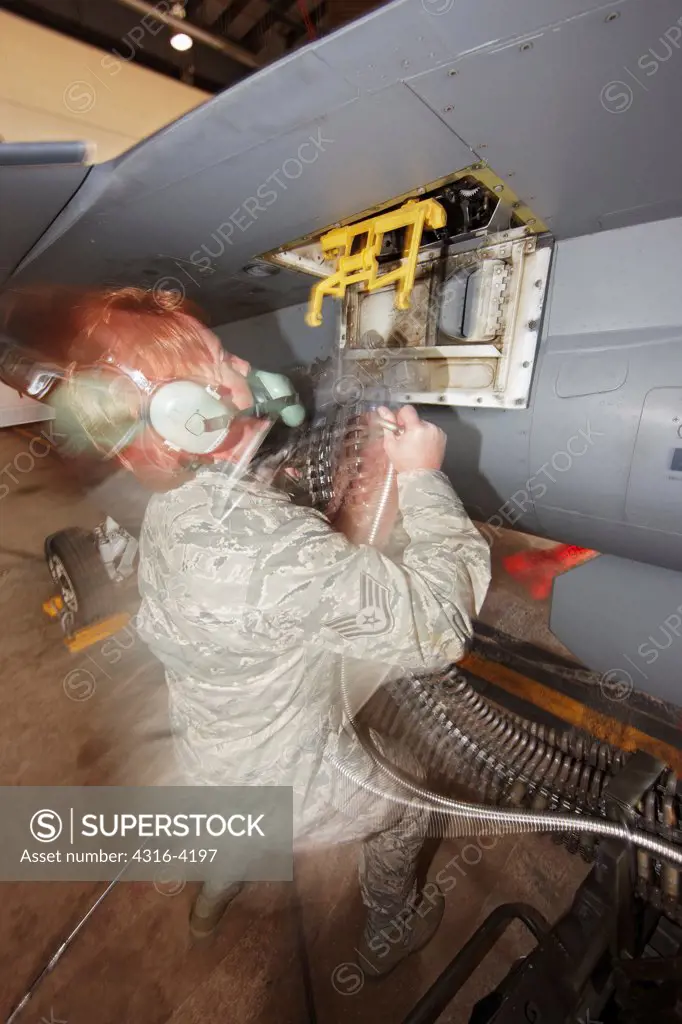 Ground Crew Member Loads 20mm Rounds (Bullets) into the Gun of an F-16