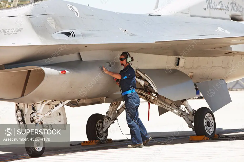 Ground Crew Member Inspects an F-16 Just Prior to Launch