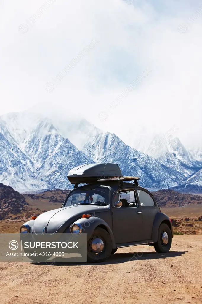 Car on Dirt Road, Mountains and Storm in Distance