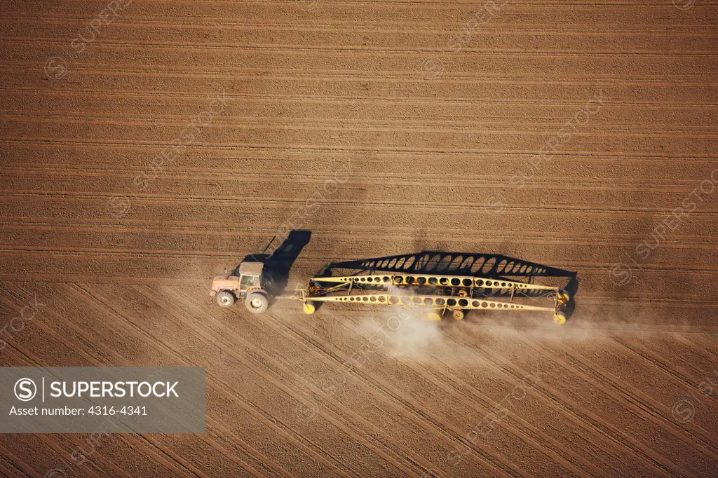 Aerial View of Tractor Planing an Agricultural Field