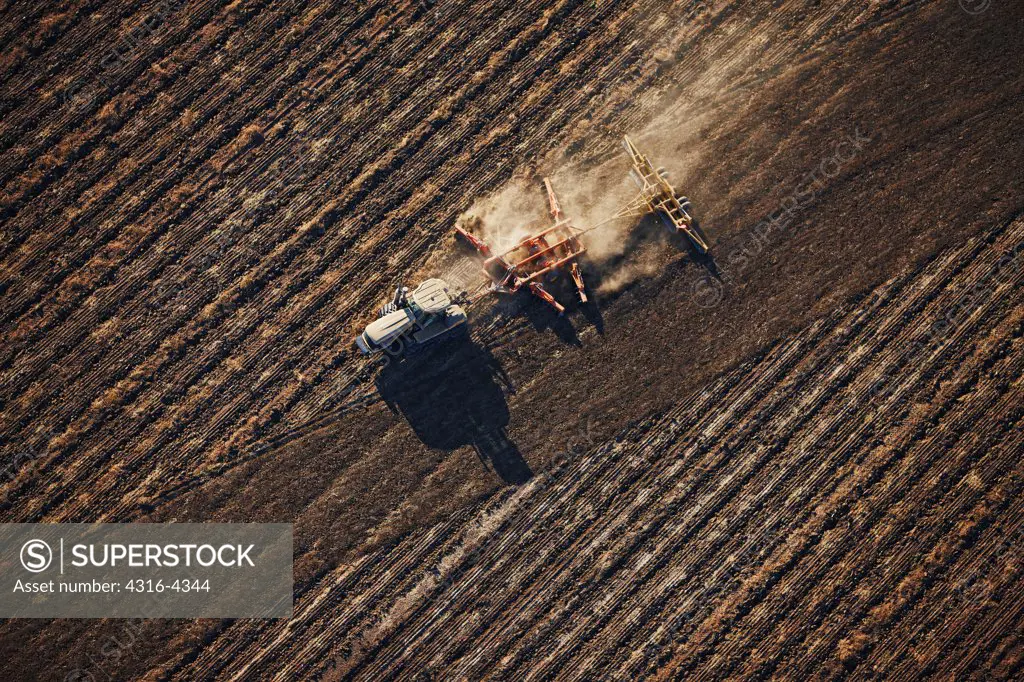 Aerial View of Tractor Pulling a Disc Set to Prepare an Agriculture Field for Crop Planting