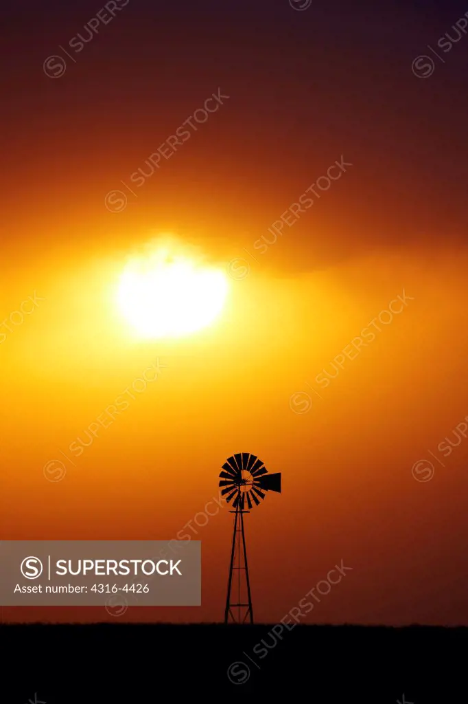 Windmill silhouetted by the setting sun, USA