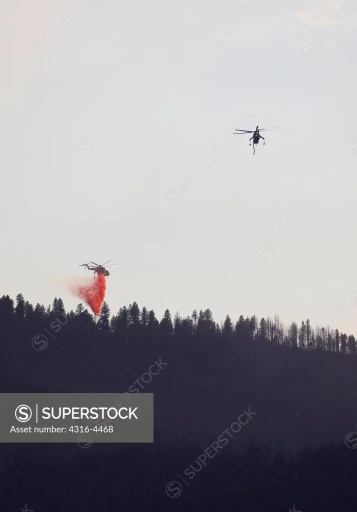 Large firefighting helicopters dump fire retardant on raging wildfire, Colorado, USA