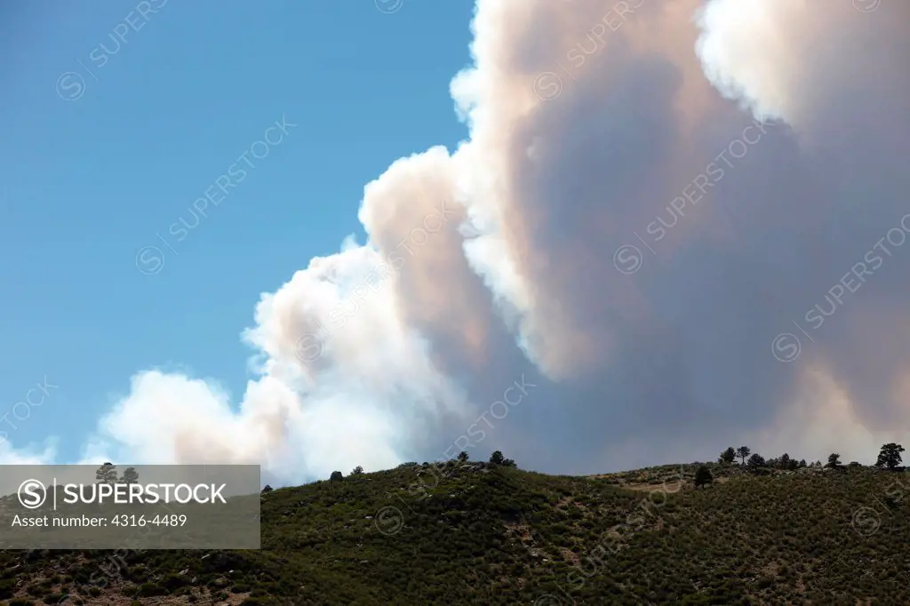 Rising plume of smoke from raging mountain wildfire, Colorado, USA