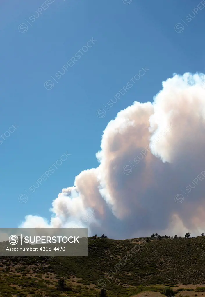 Rising plume of smoke from raging mountain wildfire, Colorado, USA