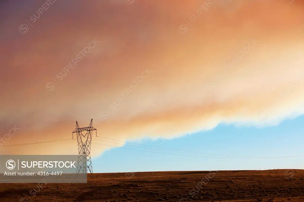 High voltage power line, smoke from raging mountain wildfire, Colorado, USA