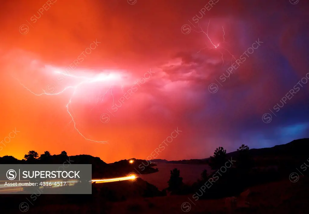 Lightning and streak of car headlights, Colorado, USA