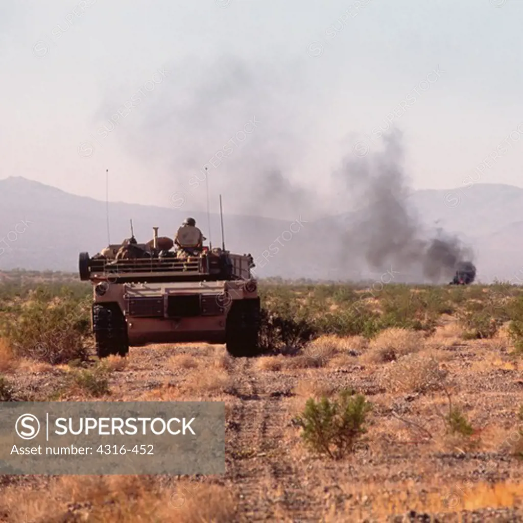 M1A1 Abrams Battle Tank Approaches a Smoking Hulk Just Hit by its Main Gun