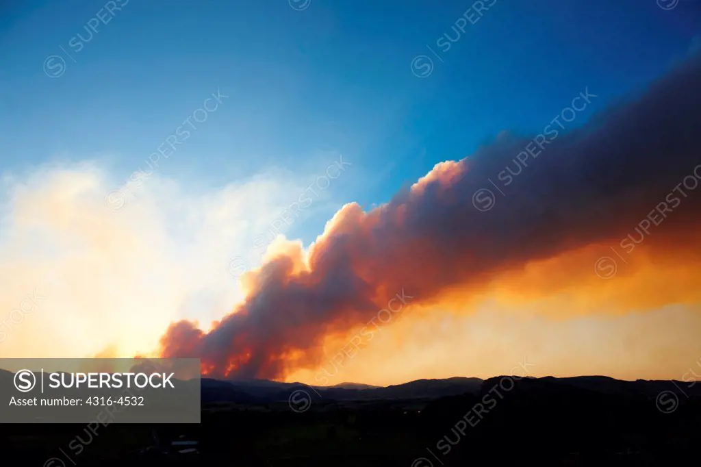 Plume of smoke rises from raging mountain wildfire, Colorado, USA