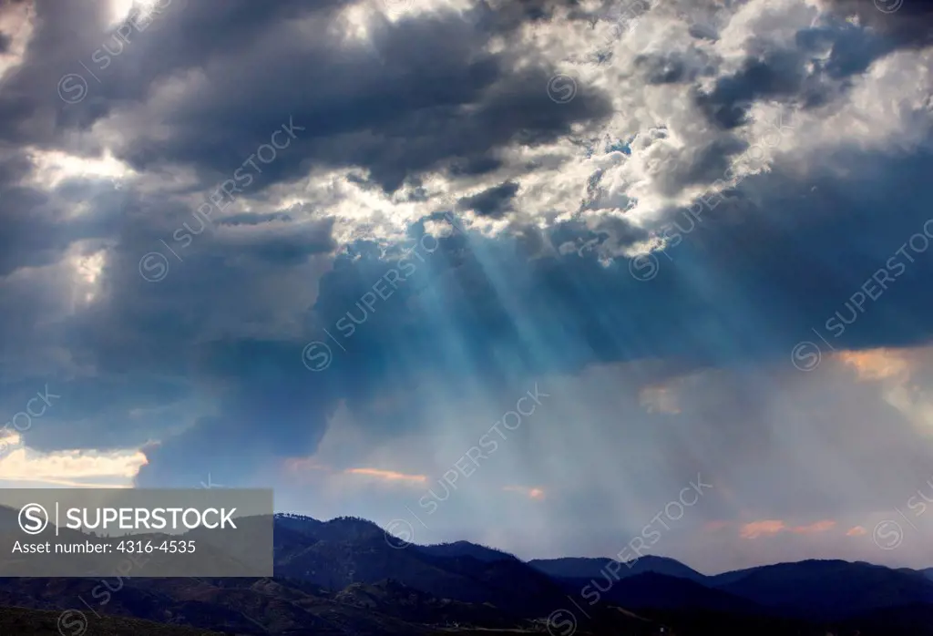Crepuscular rays, dense plume of smoke from raging mountain wildfire, Colorado, USA