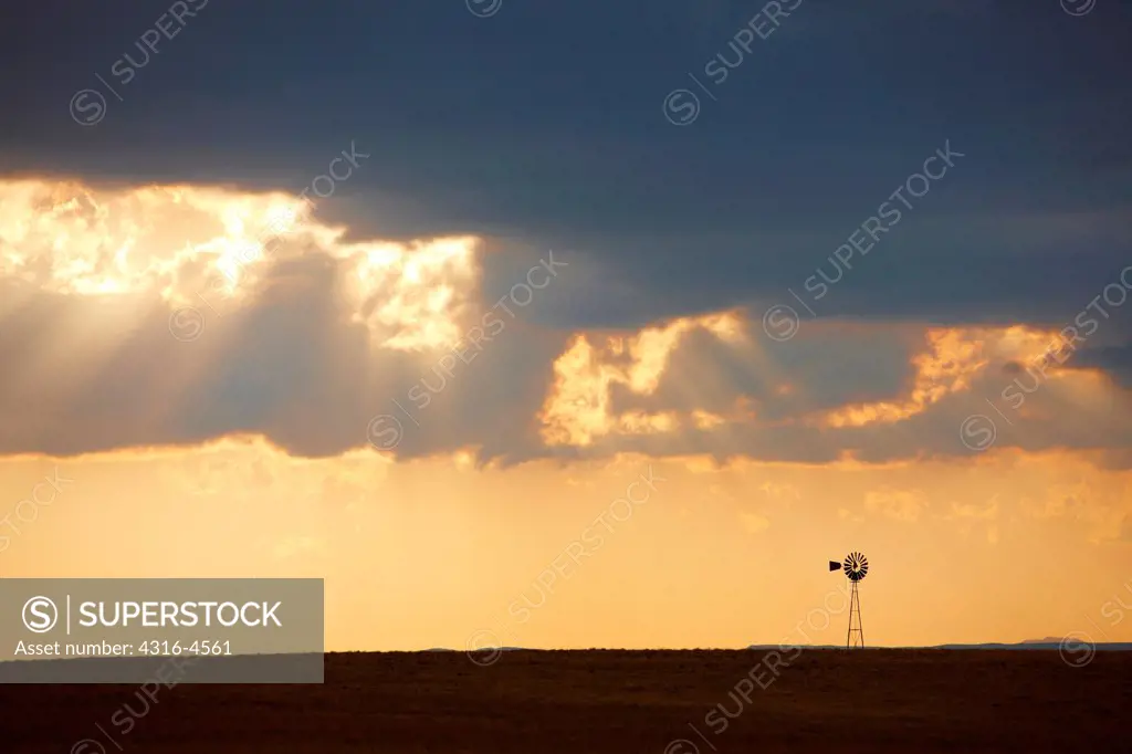 Thunderstorm, crepuscular rays, and lone windmill, Colorado, USA