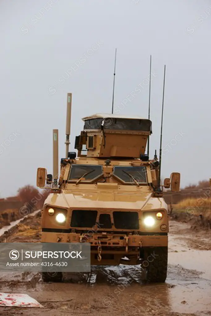 M-ATV, or Mine Resistant, Ambush Protected, All Terrain Vehicle, drives down muddy dirt road, Marjah, Afghanistan