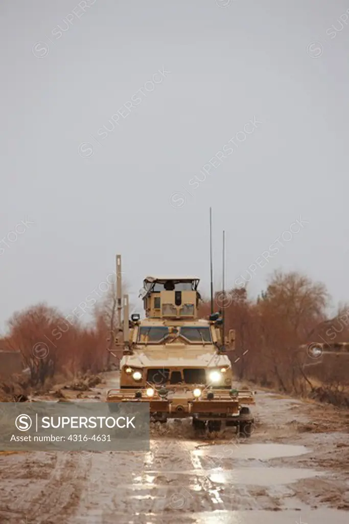 M-ATV, or Mine Resistant, Ambush Protected, All Terrain Vehicle, drives down muddy dirt road, Marjah, Afghanistan