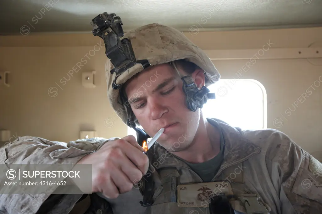 United States Marine smoking cigarette inside MRAP during a combat operation in Afghanistan's Helmand Province