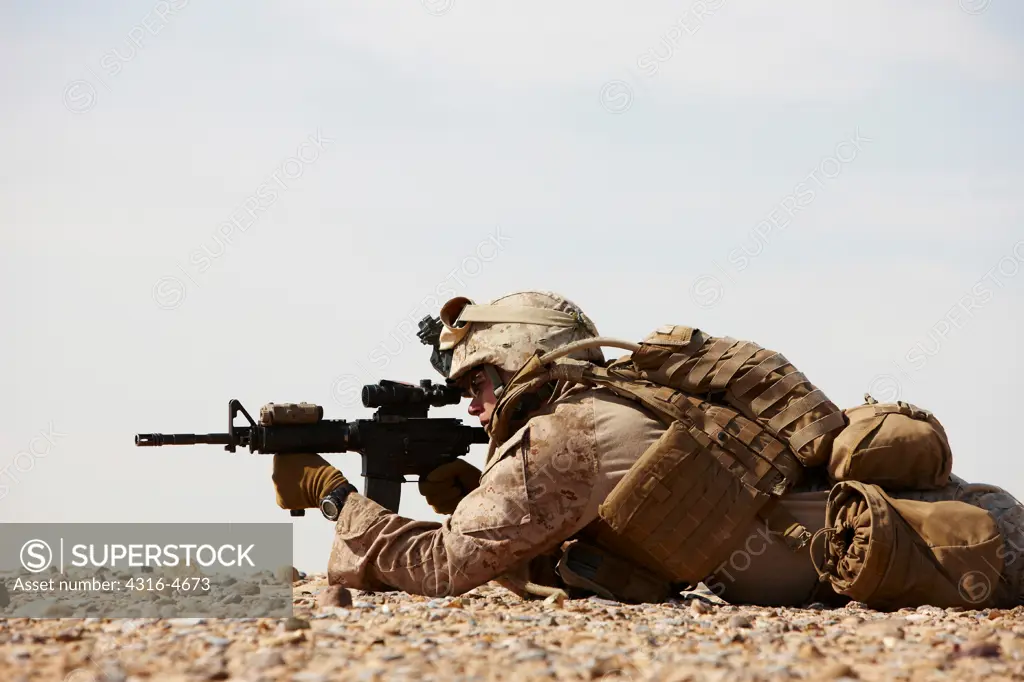 United States Marine aims an M4 carbine during a combat operation in Afghanistan's Helmand Province