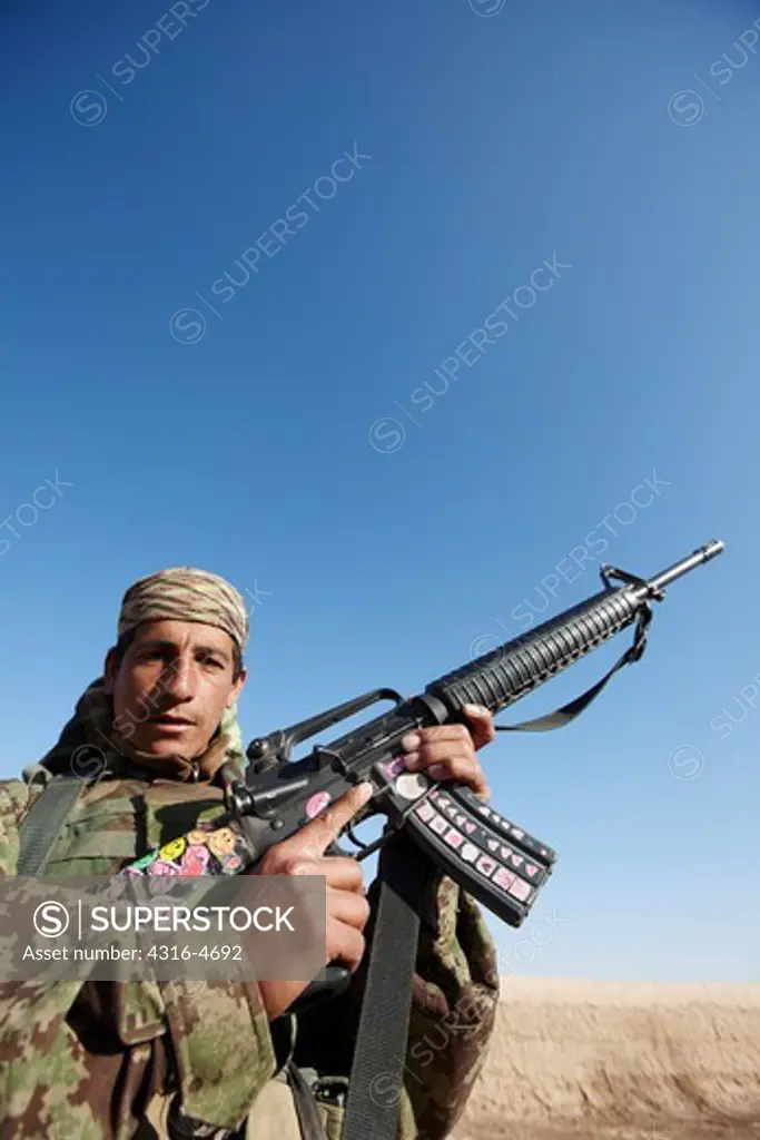 Afghan National Army Soldier shows off his M-16 which is adorned with childish stickers