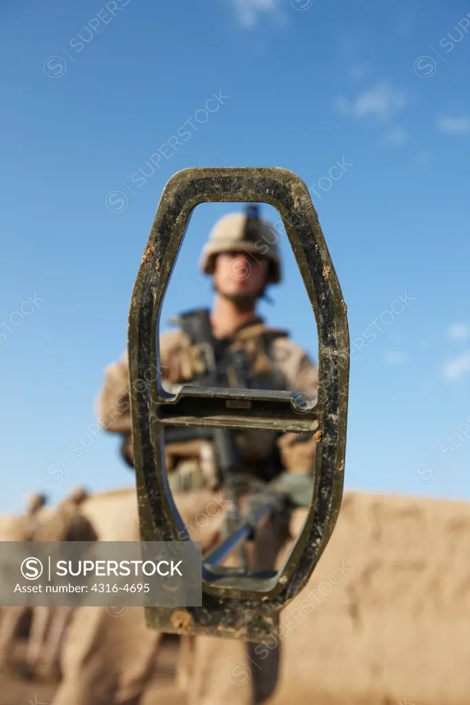 United States Marine combat engineer holds up his metal detector used to search for hidden explosives and weapons