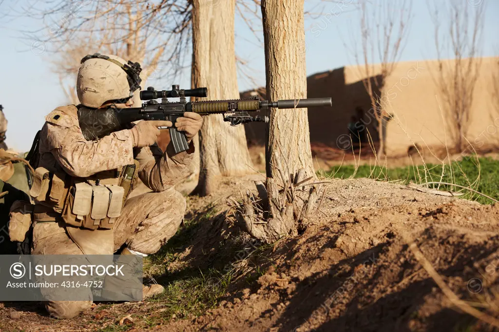 A U.S. Marine aims a Designated Marksman Rifle during a combat operation in Afghanistan's Helmand Province