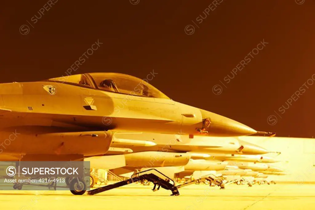 Line of F-16 Fighting Falcons on flight line at night