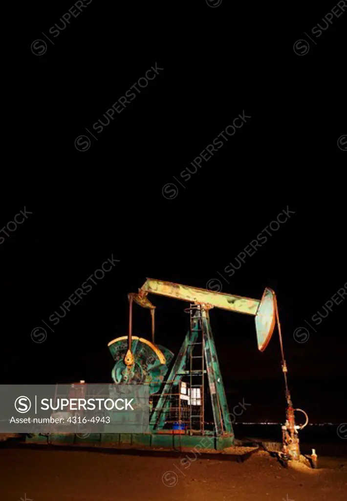 Oil well pumpjack at night