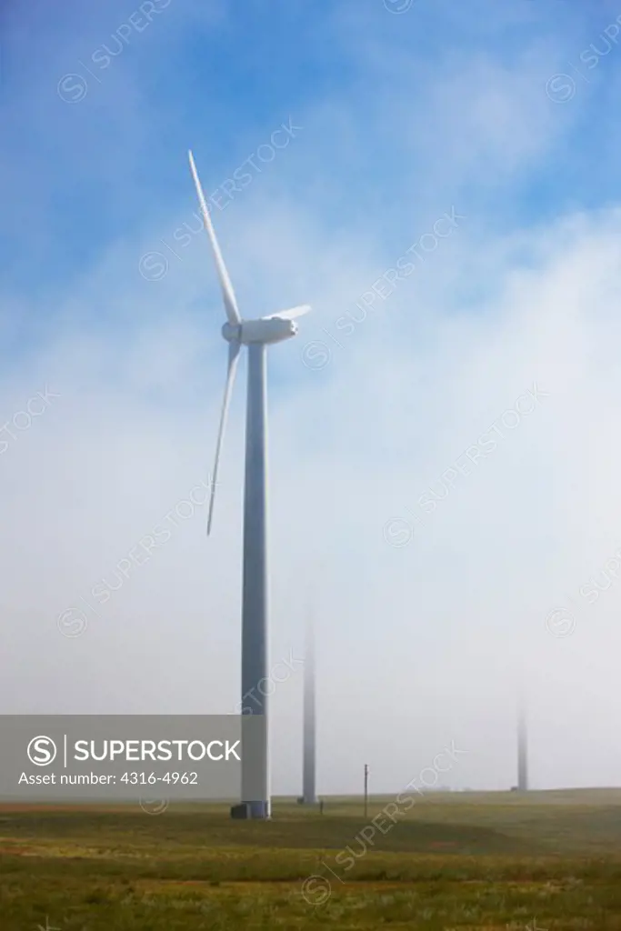 Clouds envelop wind turbines at a wind farm, Colorado