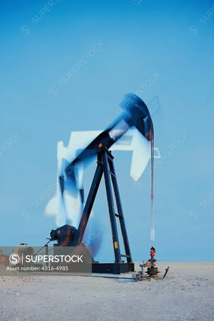 Oil well pump jack at work, blurred view
