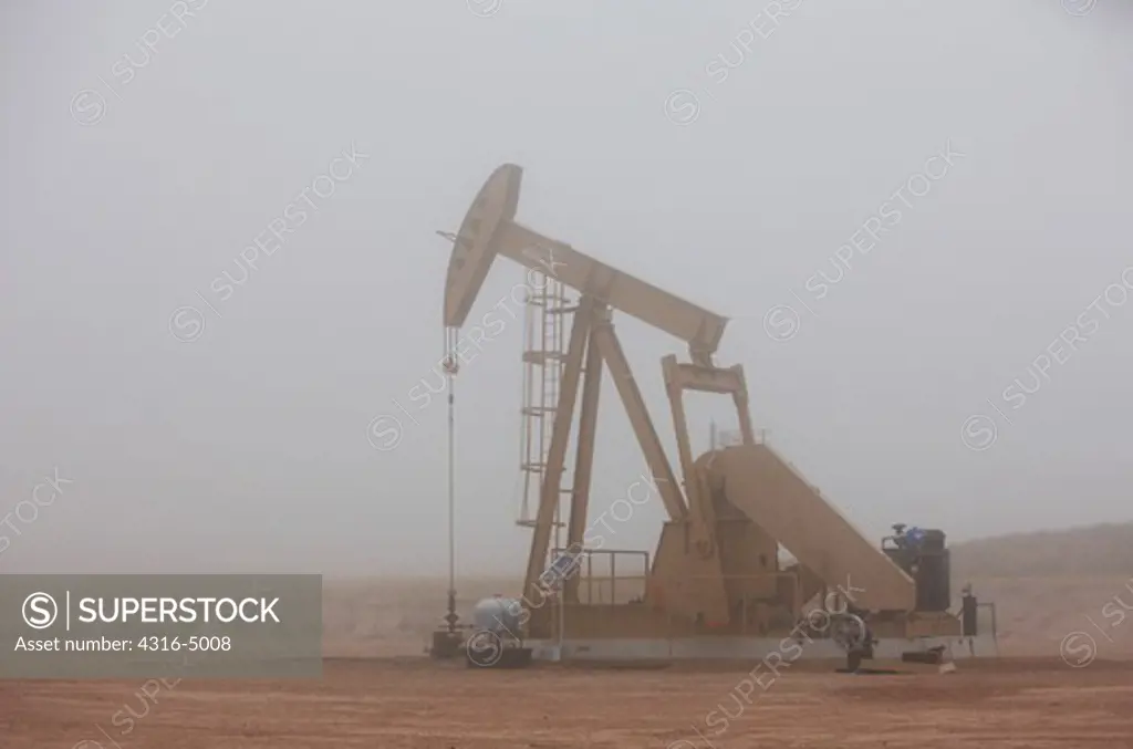 Oil well pumpjack in fog