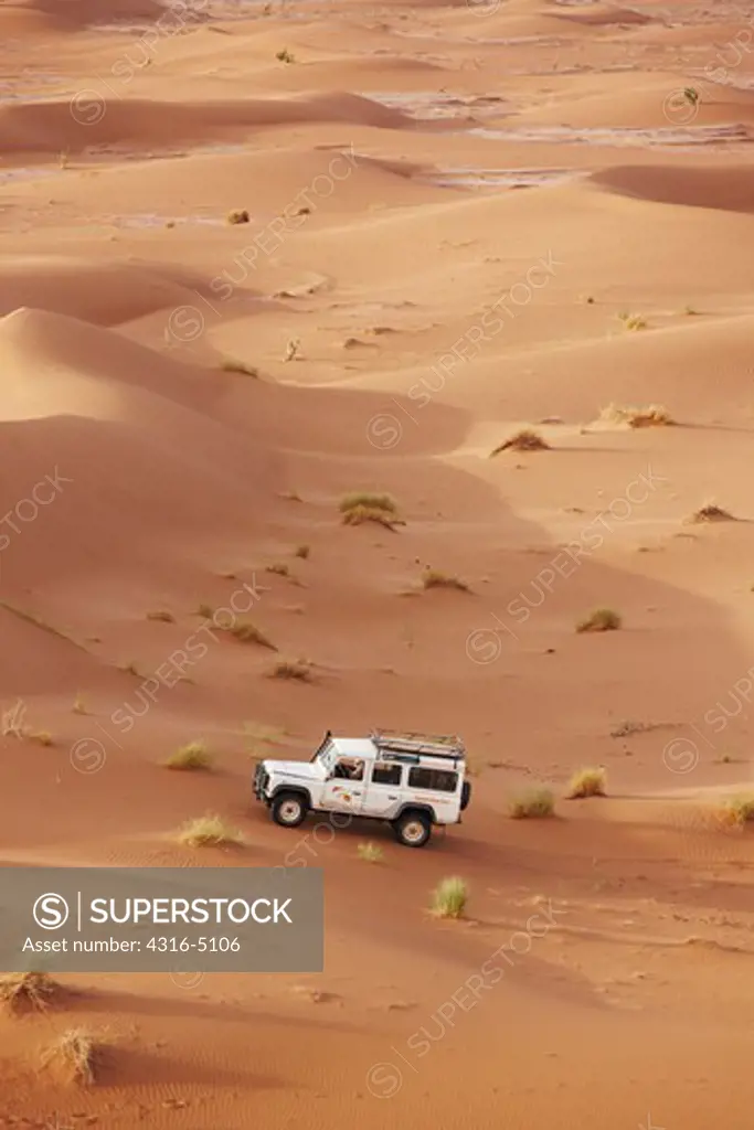 Land Rover crossing sand dune field, interior Sahara Desert, Morocco
