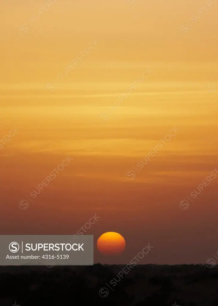 View of setting sun through Harmattan Haze, interior Sahara Desert, Morocco