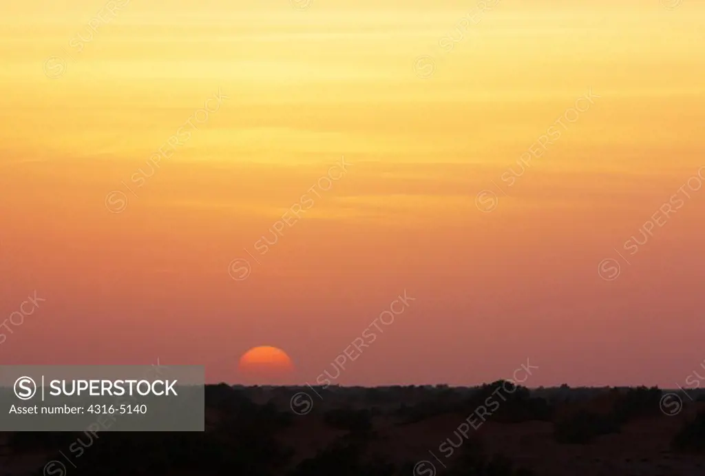 View of setting sun through Harmattan Haze, interior Sahara Desert, Morocco
